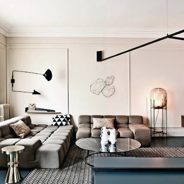Modern living room with modular sofas, geometric decor, and minimalist lighting fixtures.