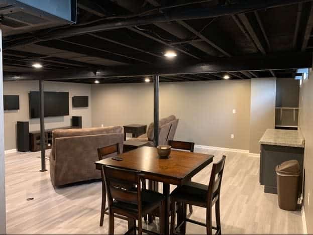 simple basement room brown table and chairs couch large tv