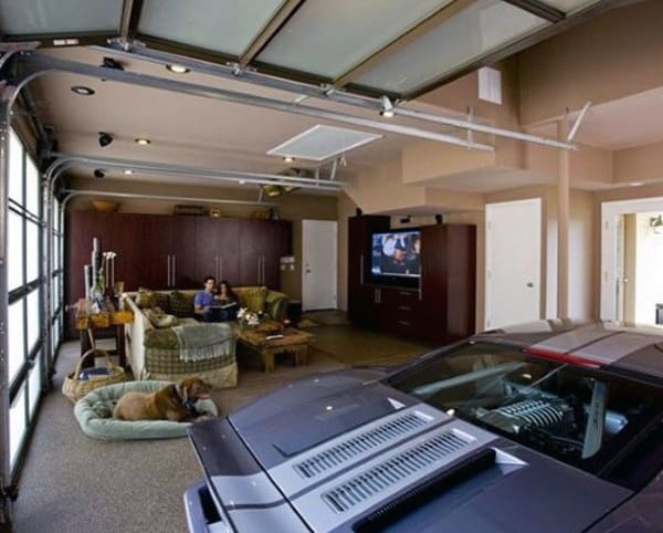 A cozy garage featuring a luxury car alongside a comfortable living room setup with a couch and pet-friendly space.