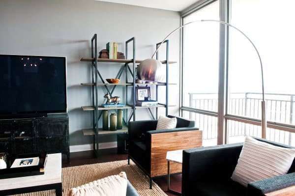 Sophisticated living room with black chairs, modern bookshelf, and floor-to-ceiling windows.