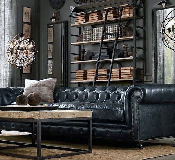 Elegant living room with tufted leather sofa, industrial-style bookshelf, and wooden coffee table.