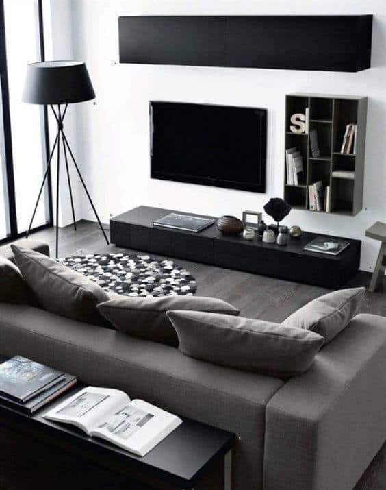 Modern living room with gray sofa, minimalist decor, and black media console.