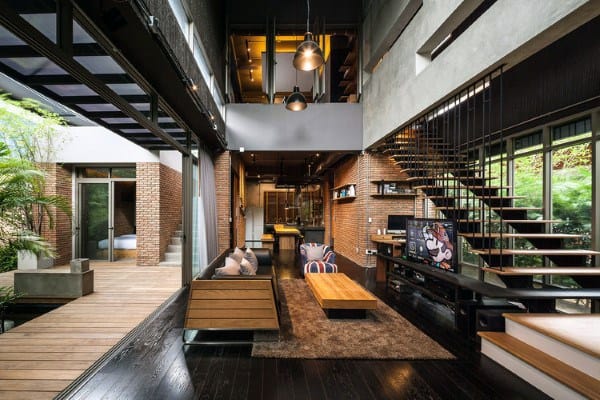 Industrial loft with open stairs, brick walls, and modern rustic decor.