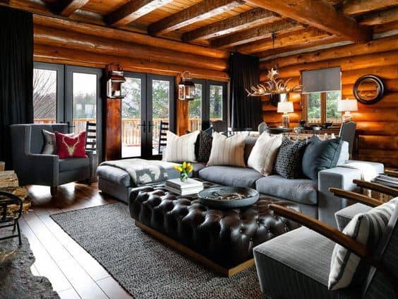 Modern log cabin living room with cozy seating, wood accents, and large windows for natural light.