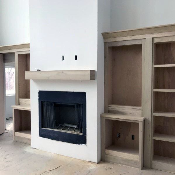 living room media center bookcase wood hidden door fireplace