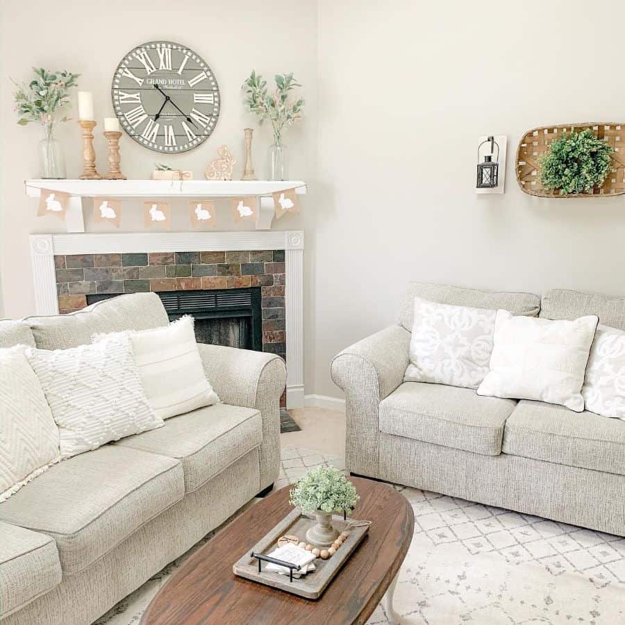 neutral color farmhouse living room with gray sofas and stone fireplace