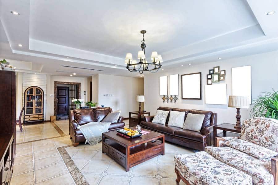 country style living room leather couches wood coffee table chandelier