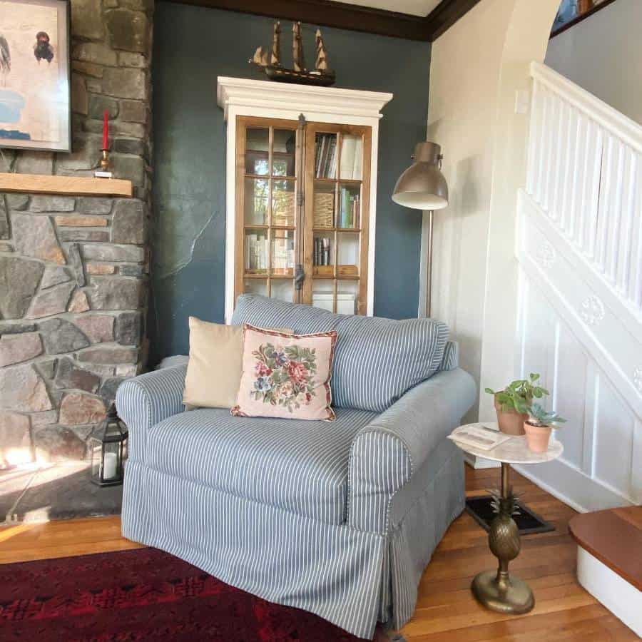 country living room blue feature wall stone fireplace stripe blue and white lounge chair 