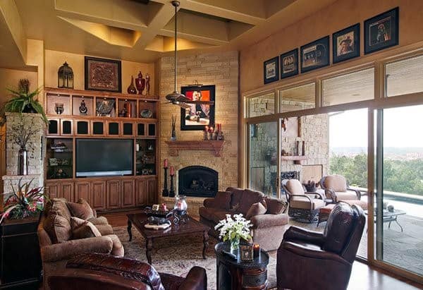 Spacious living room with stone corner fireplace, leather seating, and built-in wooden cabinets.
