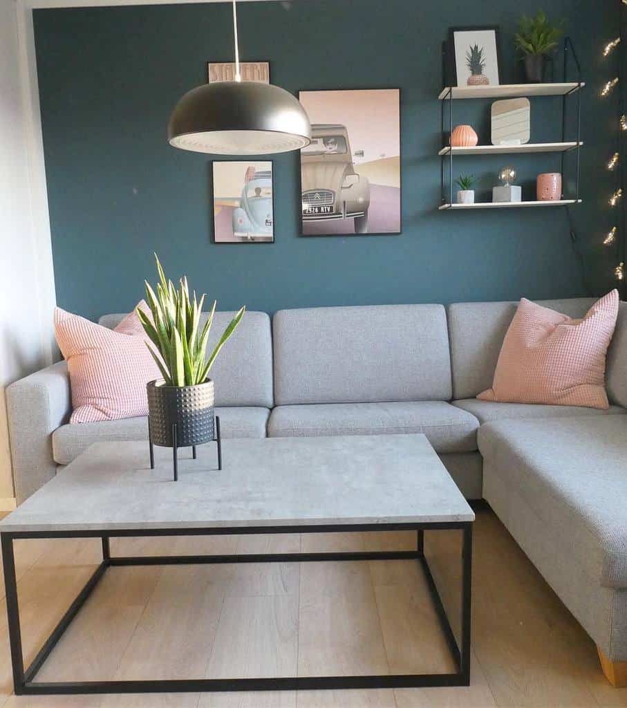 green accent wall in small basement living room with gray sofa