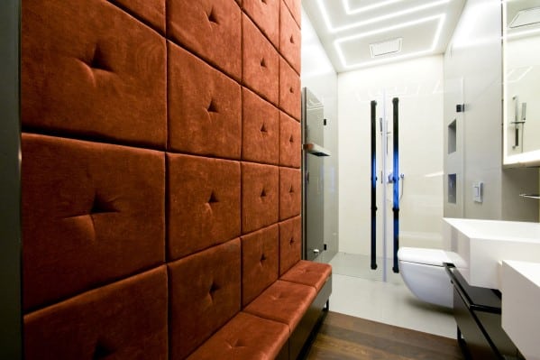 Modern restroom with red tufted wall, white fixtures, and ceiling lights