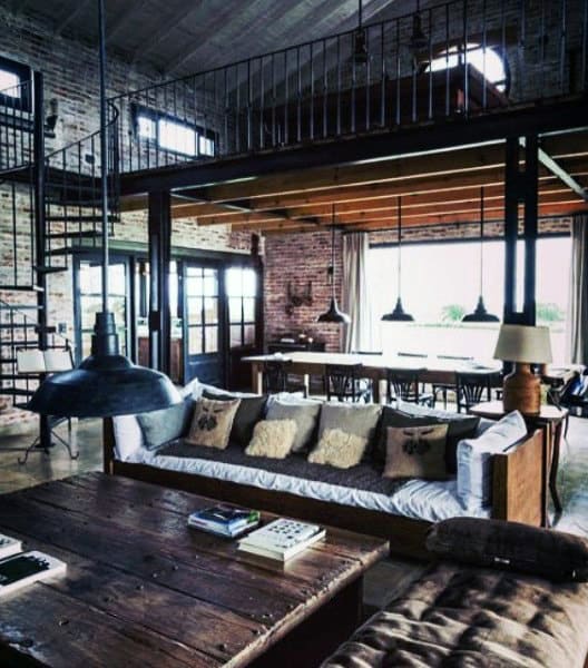 Industrial loft space with exposed brick, wood accents, spiral staircase, and open layout.