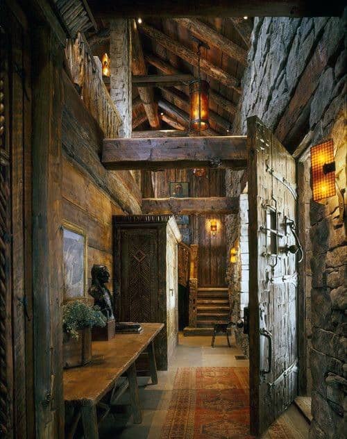 Rustic log cabin hallway with wooden beams, stone walls, and warm ambient lighting.