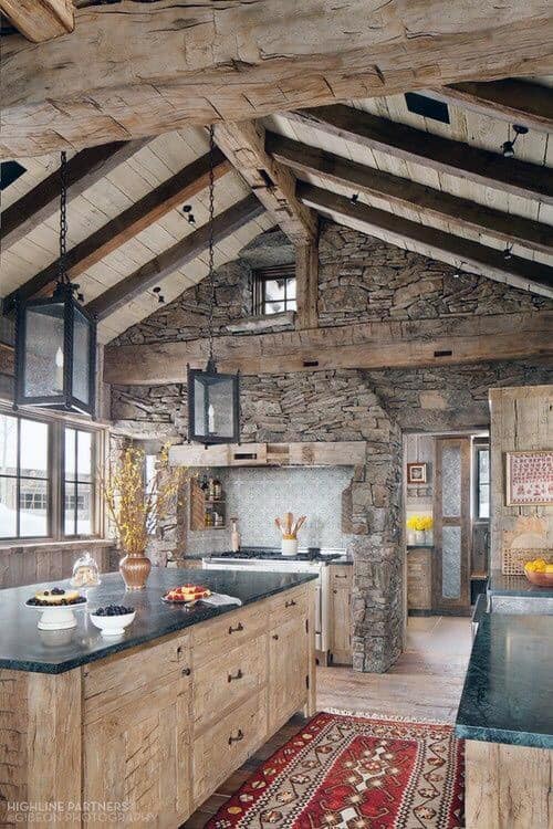 Rustic kitchen featuring exposed wooden beams, stone walls, and warm natural textures for a charming log cabin ambiance.