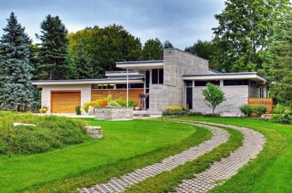 Curved permeable paver driveway with grass-filled gaps, blending seamlessly with the surrounding lawn.