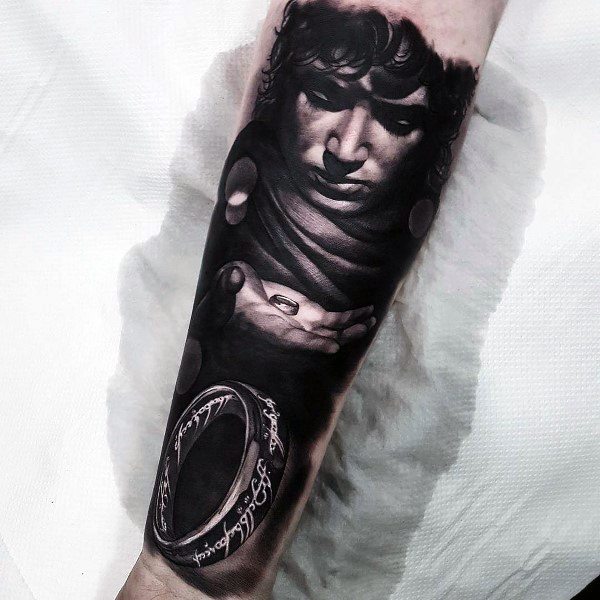 Realistic Lord of the Rings tattoo of Frodo holding the One Ring, capturing the burden, power, and darkness of the journey.