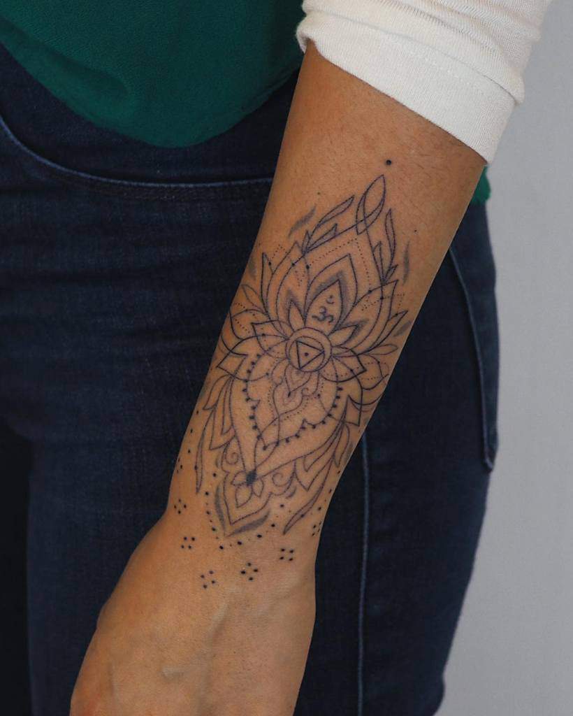 Intricate mandala design stretches from the wrist to the forearm, rendered in stunning black ink