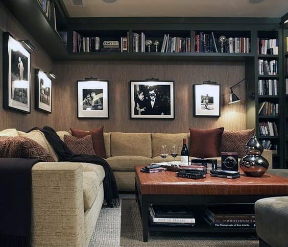 Cozy living room with beige sofa, framed photos, bookshelves, and a coffee table with decor and wine glasses
