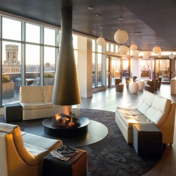 Suspended cone fireplace in a modern lounge with sunset views.