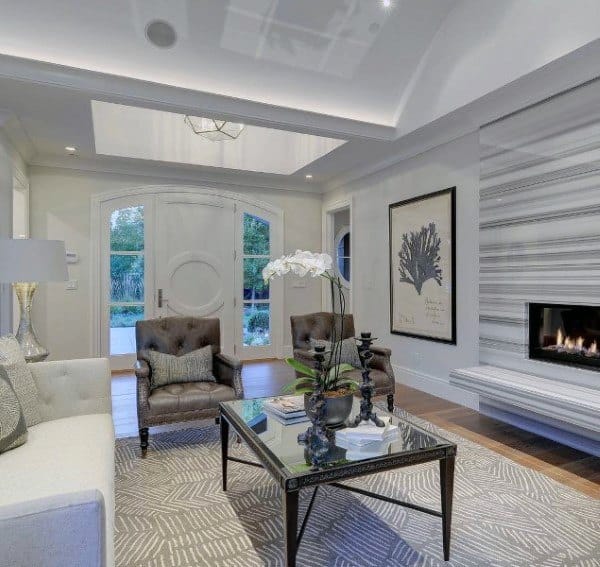 Elegant living room with striped fireplace wall, vaulted ceiling, and sophisticated seating arrangement.