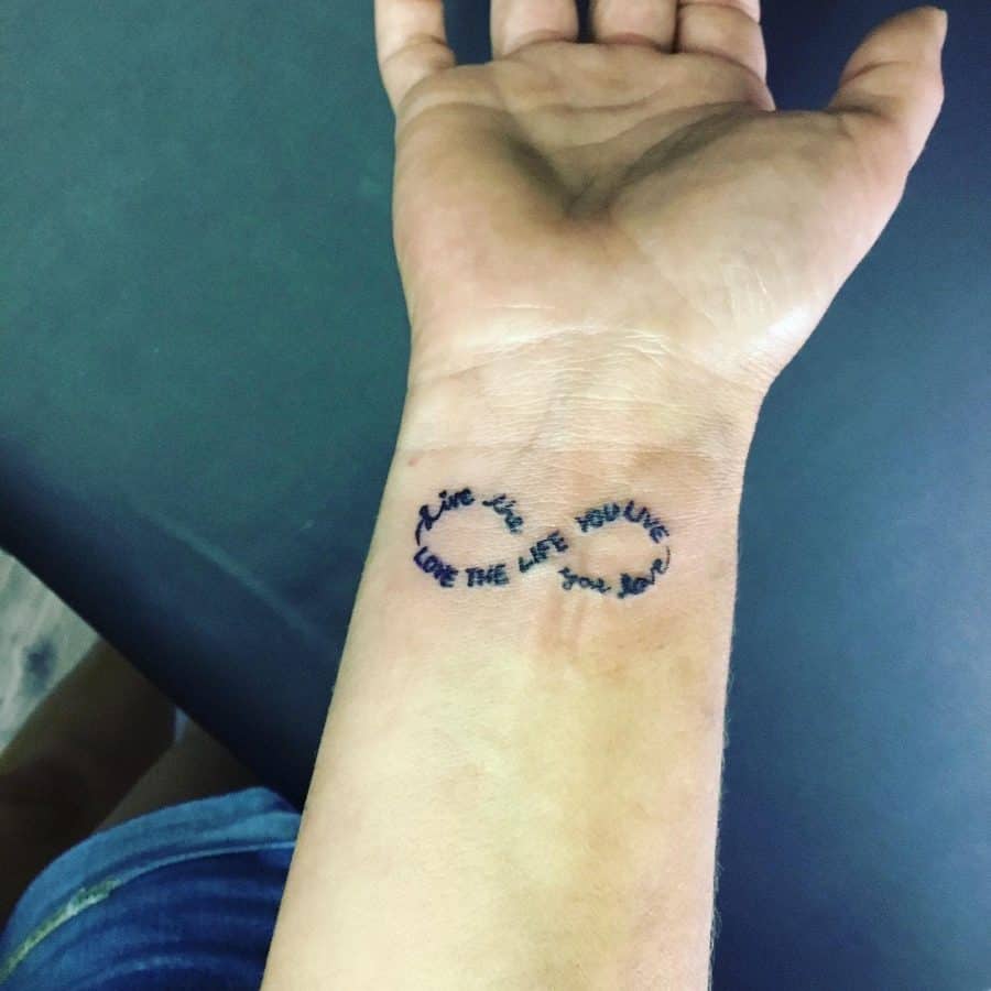 This tattoo features the inspiring words "Live the life you love, love the life you live" within an infinity symbol, representing the idea of eternal positivity and self-fulfillment.