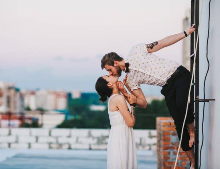 lovely couple kissing each other on the rooftop