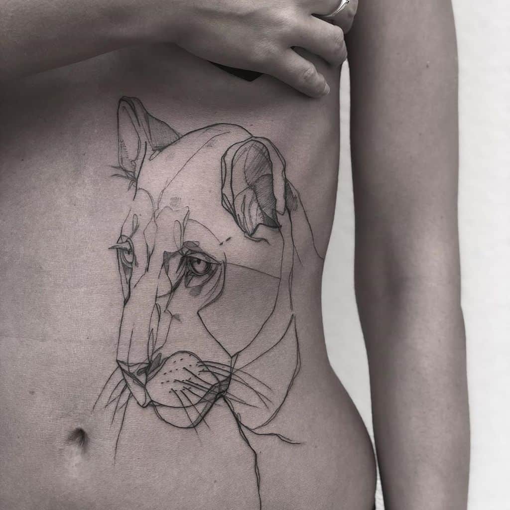 Large abstract lioness tattoo on the ribcage, featuring fine linework and geometric elements for a modern, artistic look.