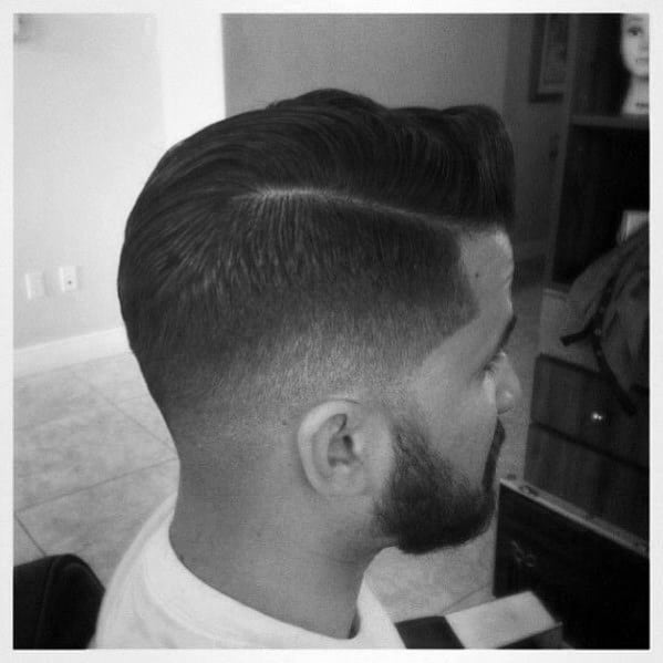 Classic comb-over with a hard part and a low fade on the sides and bac