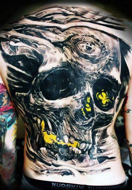 Detailed skull tattoo with yellow highlights on a person's back