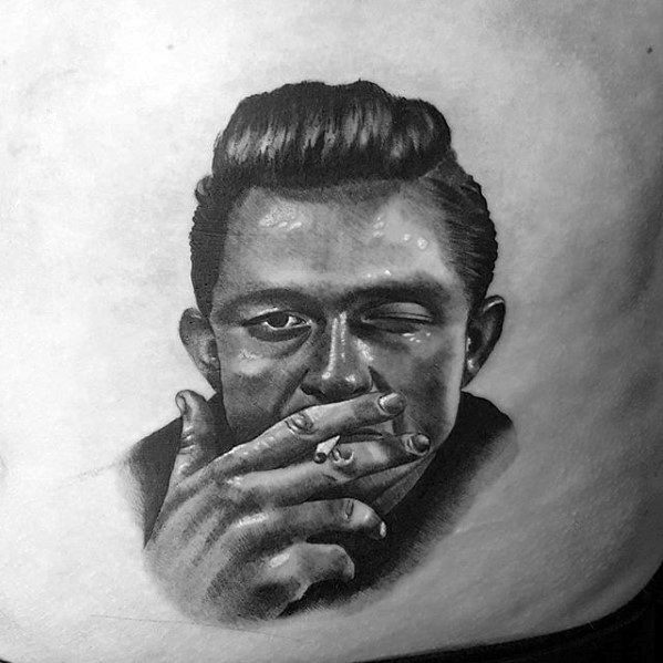 Tattoo of Johnny Cash with slicked-back hair, winking and holding a cigarette
