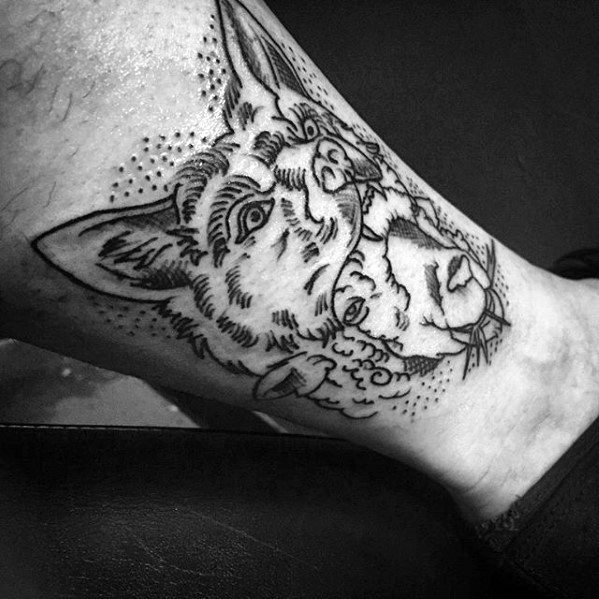 Wolf tattoo on leg, featuring a wolf's head devouring a sheep's head, done in a black outline style.