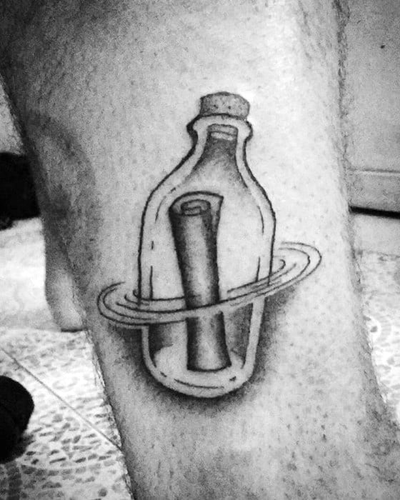 Tattoo of a message in a bottle with a scroll and ring on a person's leg
