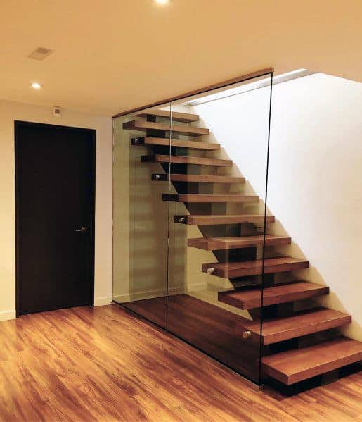 Modern floating stairs with wooden steps and glass railing in a sleek, minimalist interior design.