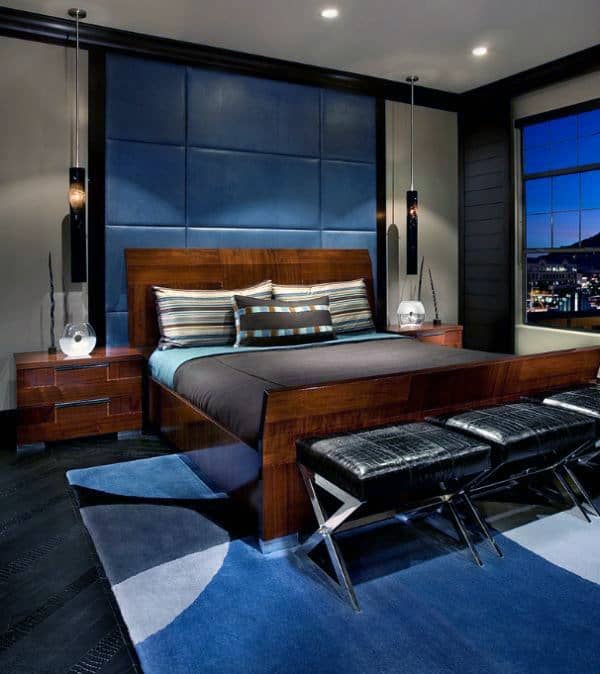 Modern bedroom with blue accents, wooden furniture, and cityscape view from window