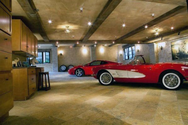 Elegant garage with vintage cars, exposed beams, warm lighting, and tiled flooring.