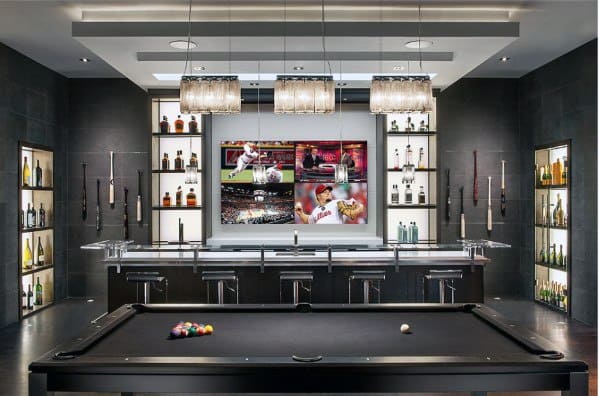 Modern man cave with a pool table, bar, and large TV screen showing multiple sports games