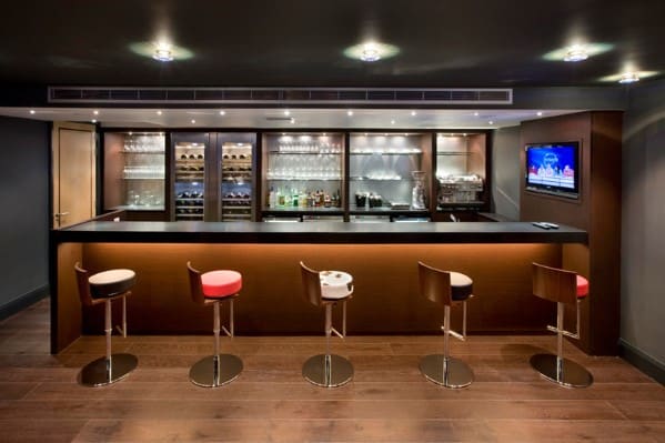 Modern bar with stools, elegant glassware, and a TV on the wall