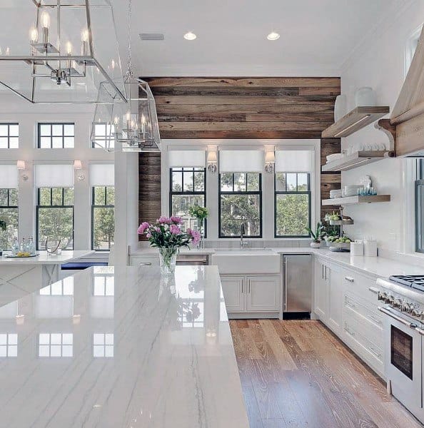 luxury white kitchen with wood shiplap accent wall and marble island 