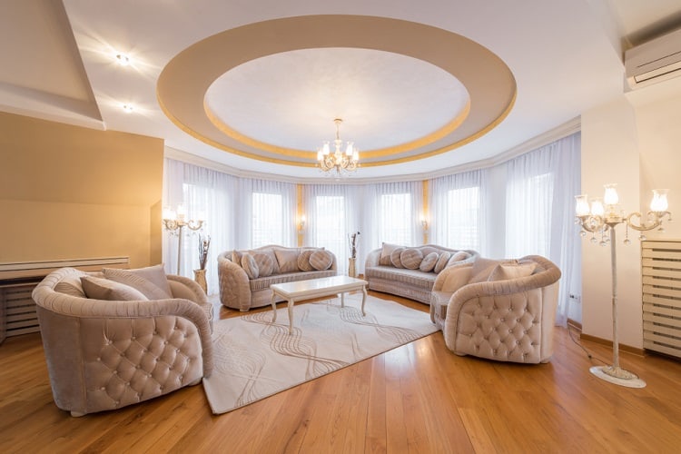 The ceiling features a luxurious round design with soft cove lighting, creating an elegant and inviting atmosphere in the living room