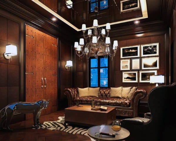 Luxurious man cave with dark wood, leather sofa, chandelier, and framed pictures, silver panther sculpture accents decor