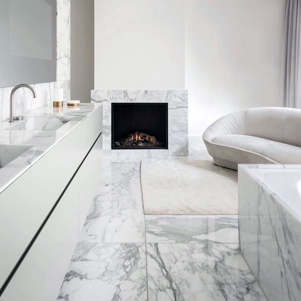 Modern bathroom with white marble flooring, built-in fireplace, and minimalist furniture.