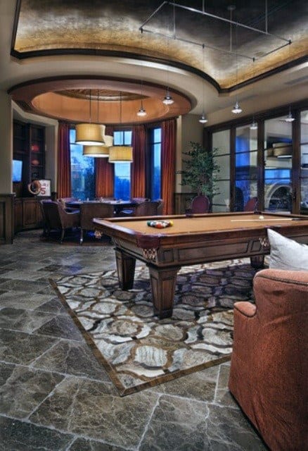Luxurious room with a pool table, seating area, and large windows, featuring elegant lighting and decor