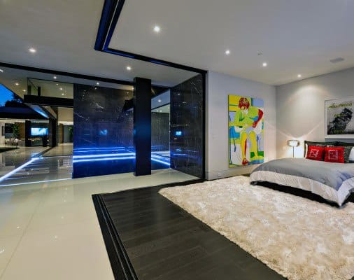 Modern bedroom with abstract art, glossy black accents, and plush area rug.