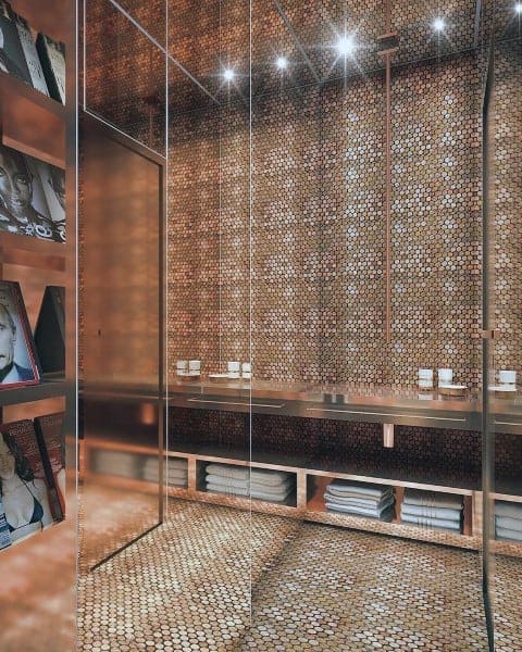 Luxury bathroom with a polished penny floor and matching wall design, illuminated by soft lighting.