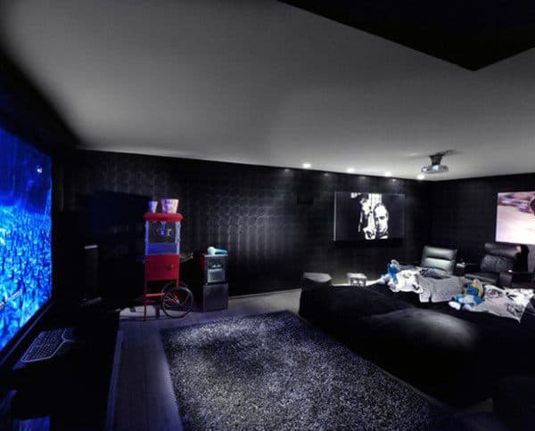 Home theater room with a large screen, black decor, popcorn machine, and cozy seating area