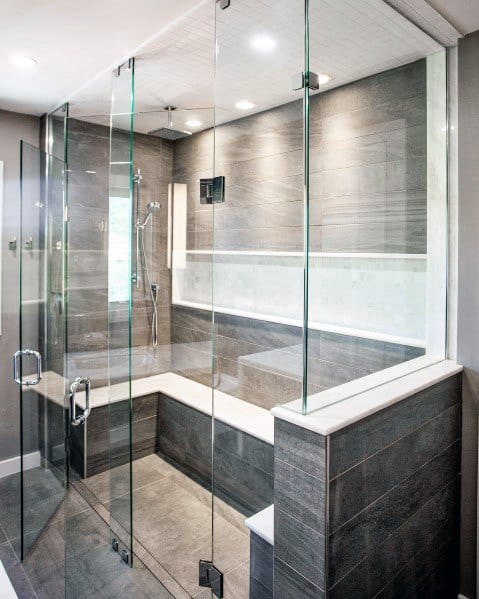 Elegant luxury shower with sleek glass walls, recessed ceiling lighting, and a spacious built-in seating area for a modern, relaxing ambiance