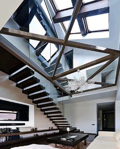 Modern interior with a sleek staircase, wooden beams, skylights, and geometric chandelier in the living room