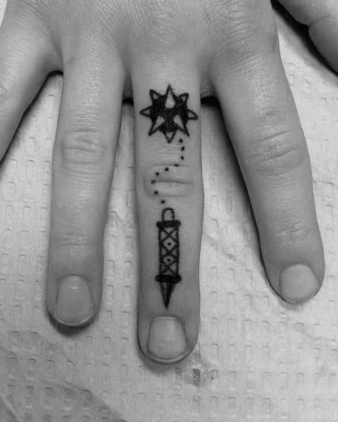 Minimalist mace tattoo on a finger, featuring a spiked ball connected to a handle by a dotted chain, symbolizing strength and resilience.