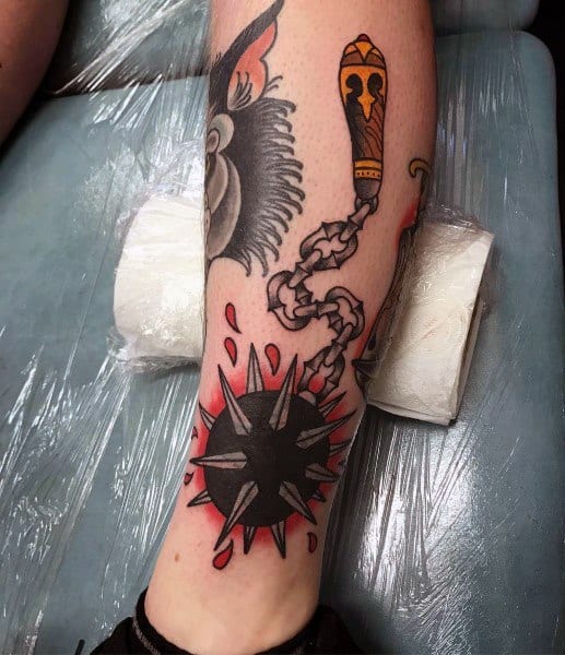Bold mace tattoo with a spiked ball on a chain, red shading, and blood splashes, symbolizing strength, battle, and medieval power.
