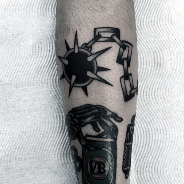 Black ink mace tattoo featuring a spiked ball on a broken chain, symbolizing strength, defiance, and resilience in a bold design.